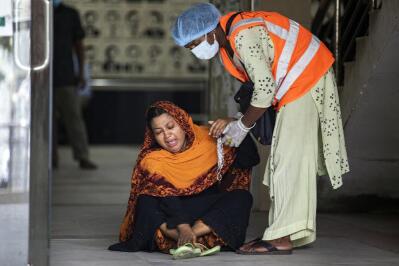 A healthcare worker assists a woman weeping on the floor