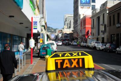 A yellow taxi sign on a car