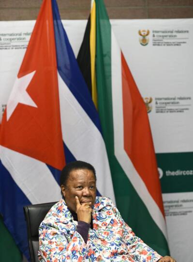A woman with flags of South Africa and Cuba behind her
