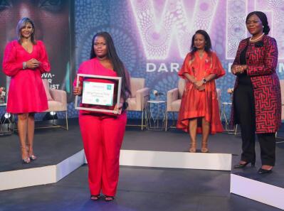 Women hold up award certificates.