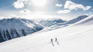 People hike up snow-covered mountains.