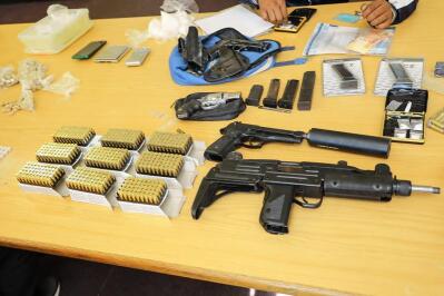 Guns, bullets, cash and drugs on a table.