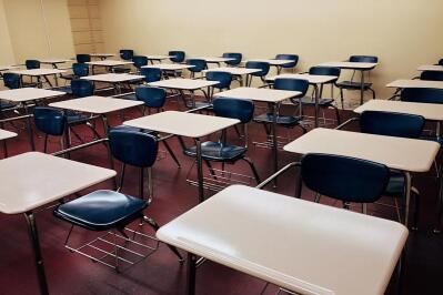 An empty classroom with chairs and desks