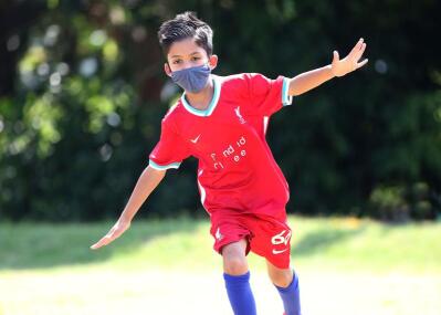 A young Liverpool fan, dress in all-red kit celebrates