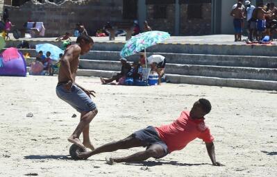 Two men playing beach soccer