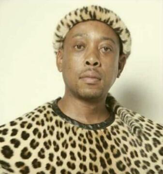 Head and shoulders image of a man wearing traditional leopard skins. 