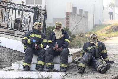 Firefighters sit on the steps.