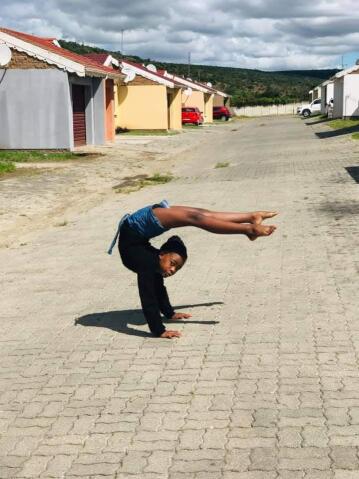 A contortionist bends in the street.
