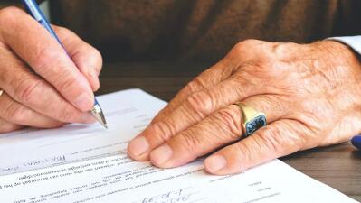 A man signs a document.