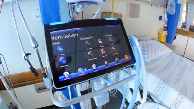 Ventilator next to hospital bed.