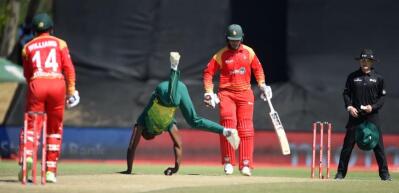 Zimbabwe batting against South Africa with the bowler diving to field the ball