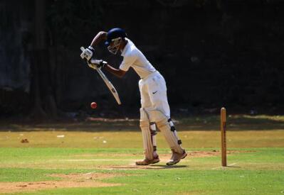 A left-handed batsman plays a defensive stroke