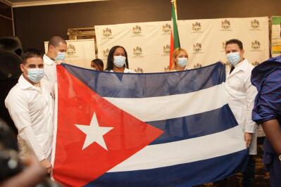 People in white waistcoats holding the Cuban flag