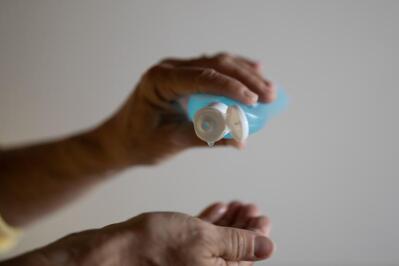 A person squeezes sanitiser onto their hand.