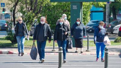 People crossing the street and wearing masks