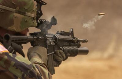 A soldier aims a rifle.