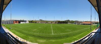 A panormaic view of a green rugby field 