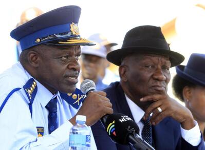 A policeman in blue uniform sitting next to a man in a suit