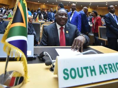 A man sitting next to the South African flag