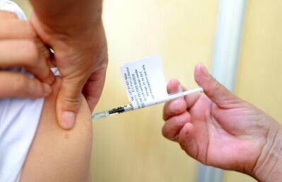 An injection is given into a person’s shoulder.