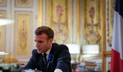 France’s President Emmanuel Macron seated at a desk.