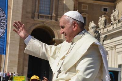 Pope Francis waving his hand from a Vatican balcony.