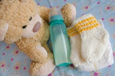 Teddy bear with baby’s feeding bottle.