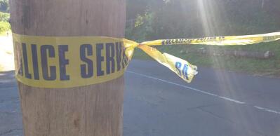Yellow police crime scene tape wrapped around a pole