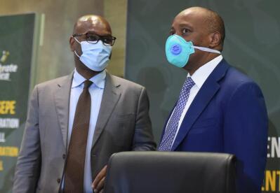 Minister of Sport, Arts and Culture, Nathi Mthethwa and newly-elected Confederation of African Football(CAF) president Patrice Motsepe in discussion, both wearing business suits and masks